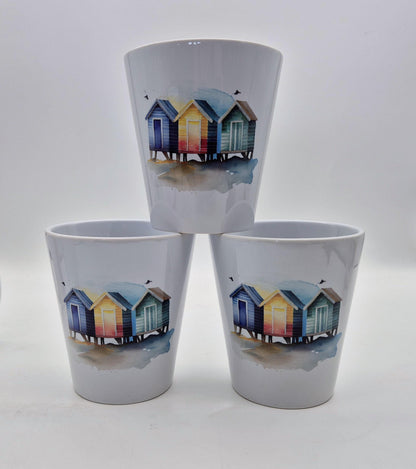 Three ceramic plant pot with beach hut design on a white background